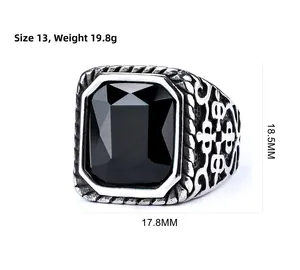 Detail view of vintage stainless steel ring with black gemstone and engraved patterns