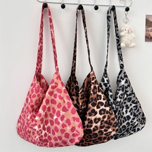 Detailed view of large canvas tote bags in three distinct leopard print color patterns