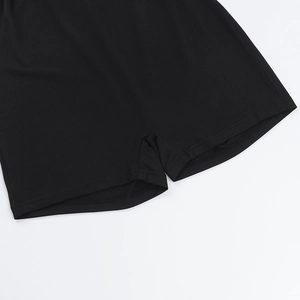 Dettaglio ravvicinato dell'orlo con doppia cucitura su pantaloncini neri in maglia elasticizzata