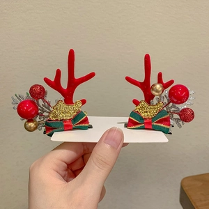 Detail of reindeer antler hair clips with Merry Christmas bows and gold berries