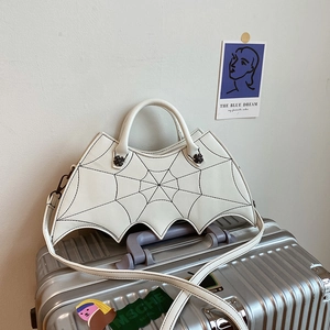Detail of white bat-wing shaped PU bag with black spider web stitching and metal hardware