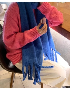 Close-up of blue cashmere-like scarf with thick tassels and soft textured knit