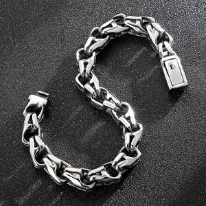 Industrial style silver titanium steel chain bracelet with a square clasp on black texture