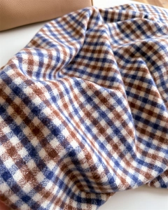 Close-up of soft cashmere-like brown and blue plaid fabric with thick scarf texture