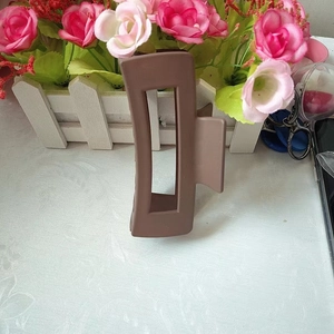 Close-up of a 10.5cm matte brown rectangular hair claw clip on a white desktop background