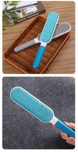 Manual lint removal brush in blue and grey being used on grey felt fabric