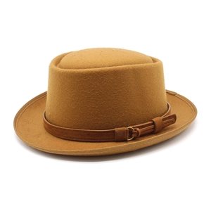 Detail of ginger wool fedora hat featuring a brown leather band and gold metal ring buckle