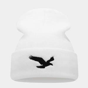 White knit beanie with black eagle embroidery in a minimalist winter streetwear style