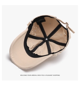 Detailed interior of a distressed beige baseball cap with frayed edges and inner brand label