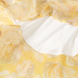 Detail of yellow floral chiffon dress showing rose print texture and smooth white lining