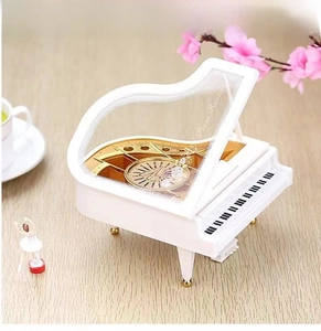 Detailed macro view of white piano music box with dancing ballerina on wooden table