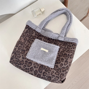 Close-up of leopard print tote with grey fleece pocket and metal Sozakka label