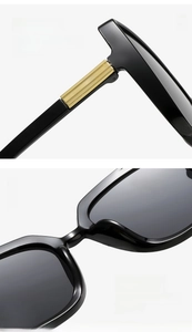 Detail of square sunglasses showing curved temples and golden decorative metal hinges