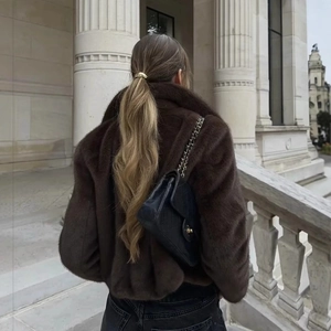 Veste en fausse fourrure marron et sac à chaîne noir dans un style urbain chic
