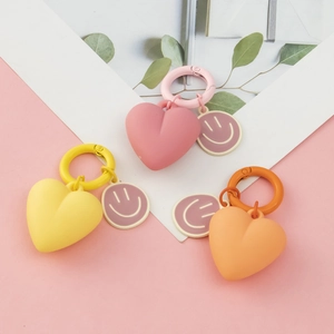 Cartoon heart and smiley face keychains in pink, yellow, and orange with metal rings