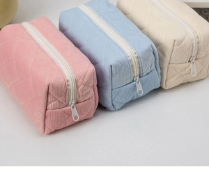 Detailed macro view of quilted corduroy makeup bags in soft macaron pink and light blue colors