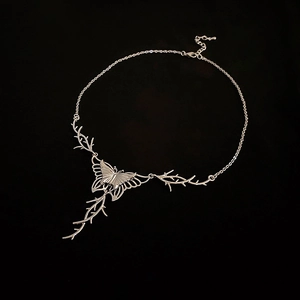 Gothic butterfly necklace with thorn branches in silver metal on black background