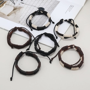 Set of six handmade woven leather and cord bracelets in casual tribal style on a neutral background