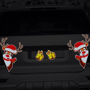 Close-up of reflective Christmas reindeer and bells car magnets on a dark vehicle