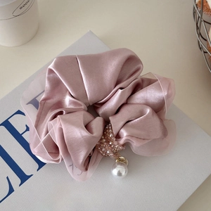 Detail of satin scrunchie in dusty rose with sparkling crystals and a pearl pendant