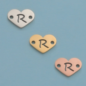 Macro view of 12mm stainless steel heart pendants with R-shaped cutout in silver, gold, and rose gold