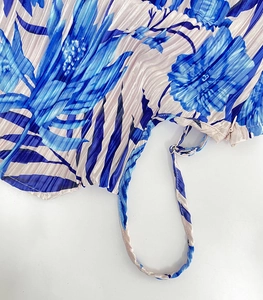 Close-up of blue floral print pleated dress featuring side invisible zipper and drawstring