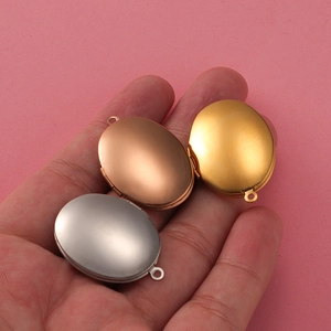 Handheld view of oval 316L stainless steel photo lockets in gold, silver, and rose gold
