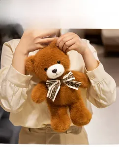 Close-up of soft brown teddy bear plush with a patterned bow tie and fluffy texture