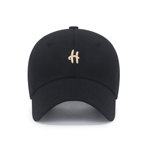 Minimalist black cotton baseball cap with embroidered golden letter H on the front