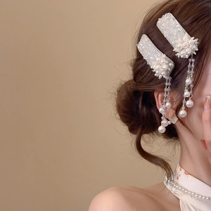 Detailed close-up of crystal flower hair clip with elegant long pearl tassels on hair