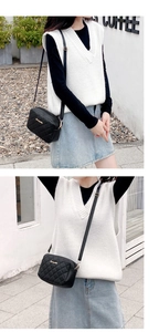 Detail of black quilted camera bag with gold hardware and adjustable shoulder strap