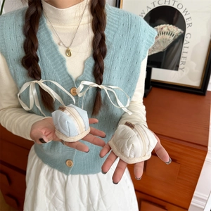 Close-up of quilted zipper pouch for AirPods in light blue and cream soft fabric