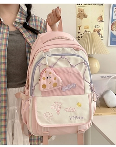 Close-up of pink and white school backpack featuring embroidery and a mini coin purse