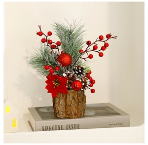 Miniature Christmas tree in bark pot with pine needles, red berries and snowy pinecones