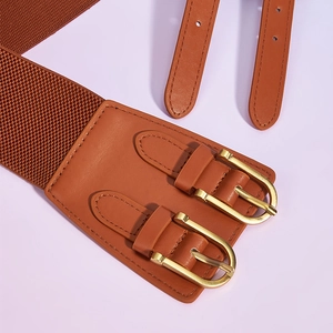 Macro shot of brown elastic waist belt with double golden metal buckles and faux leather detail
