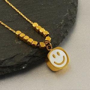 Golden stainless steel necklace featuring a smiley face pendant on a white shell inlay