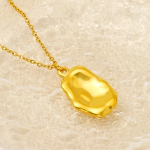 Macro view of gold lava-textured irregular pendant necklace with polished liquid metal finish