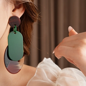 Detail view of large geometric multilayer resin earrings in green and tortoiseshell brown