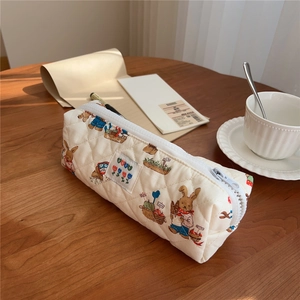 Detailed close-up of quilted cream pencil case with cute rabbit and flower prints