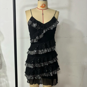 Detail of black tiered ruffles with shimmering sequins on a party camisole dress