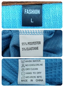 Detail view of garment care labels on blue waffle polo showing fabric composition and size L