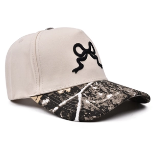 Dettaglio visiera leopardata e ricamo fiocco 3D sul berretto da baseball beige