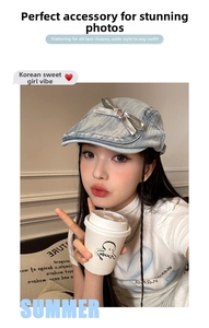 Detailed view of light blue denim beret with silver satin bow and pink heart rhinestone