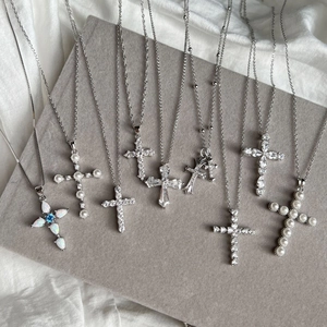 Elegant S925 sterling silver cross necklaces with pearls and opal stones on a display