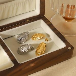 Textured gold and silver waterdrop earrings in a premium wooden jewelry storage box