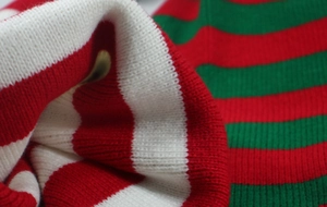 Macro detail of red, white, and green knit pattern texture on festive Christmas beanie