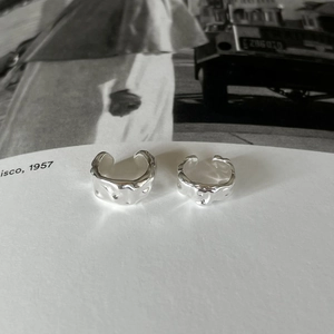 Close-up of silver textured irregular ear cuffs with liquid metal lava surface finish