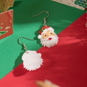 Close-up of Santa Claus face earrings with red hat and white beard on festive background