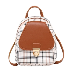 Dettaglio dello zaino vintage a quadri con patta in pelle marrone e fibbia in metallo oro