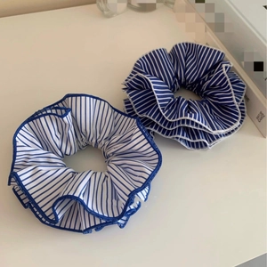 Blue and white striped fabric scrunchies with neat blue piping on white tabletop